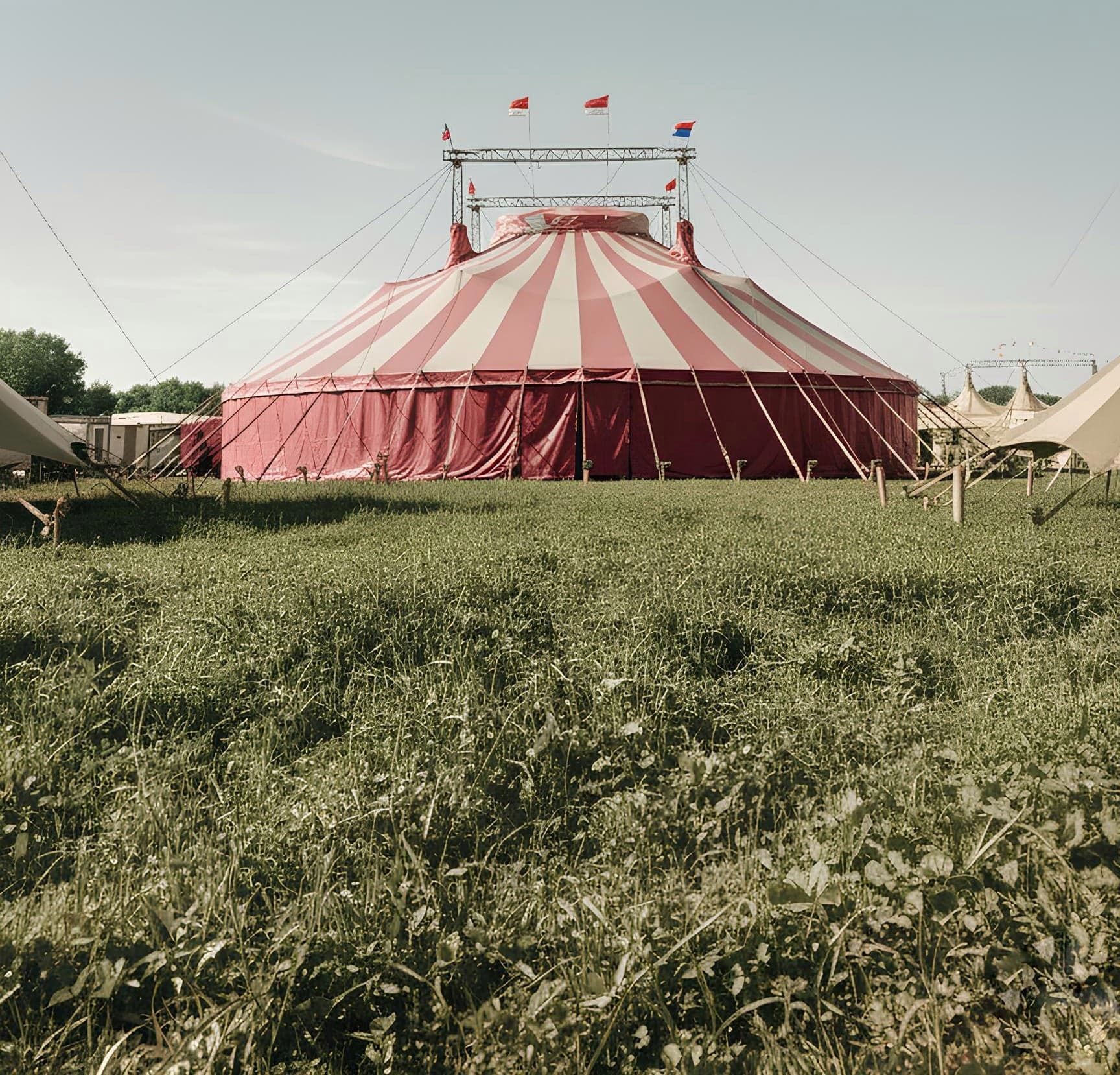 A big-top circus tent held stable by a ring of taut guy-ropes staked to the ground
